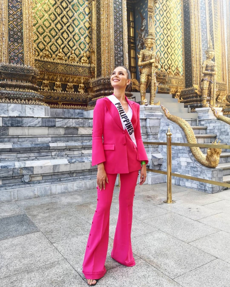 Trong chuyến thăm cung điện Hoàng gia, Catriona nổi bật lấn lướt các thí sinh khác với bộ suit màu hồng neon đến từ Erwin Flores Atelier. Gam màu 