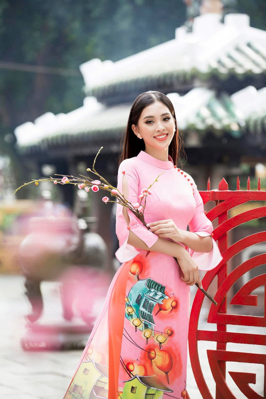 Hoa hậu Tiểu Vy thực hiện bộ ảnh áo dài Tết với những họa tiết của quê nhà Hội An: đèn lồng, phố cổ và những vách mái ngói, cành đào, cành mai. Bộ áo dài có phong cách truyền thống, kết hợp với lối trang điểm truyền thống.    