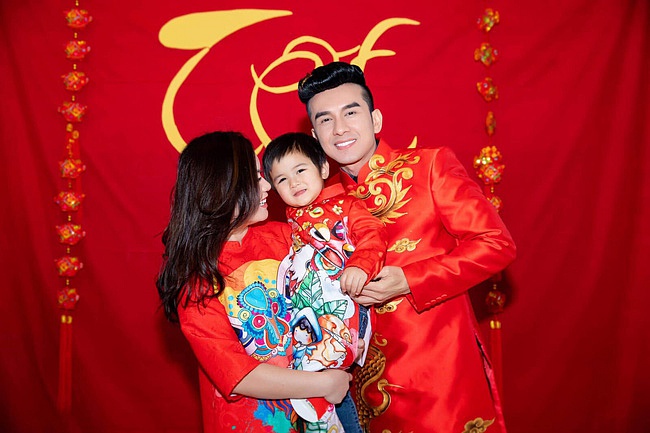 Đan Trường cùng bà xã và con trai Thiên Từ cùng nhau diện áo dài với sắc đỏ rực rỡ đón năm mới.    