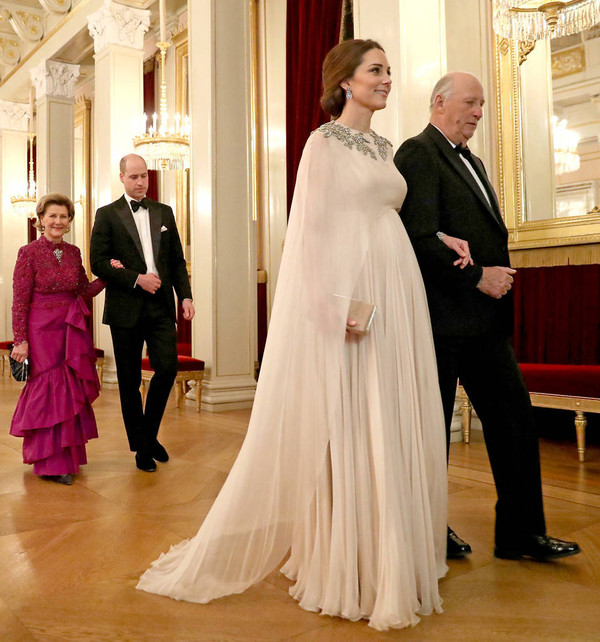 Trùng hợp thay, không biết Meghan có cố ý bắt chước công nương Kate không vì tháng 2 năm ngoái khi tham gia một bữa tiệc Hoàng Gia tại Na -Uy lúc đó cô mang bầu Hoàng tử Louis ở khoảng tháng 6, 7 . Kate Middleton cũng từng diện thiết kế váy suông xếp ly dáng cape màu hồng phấn  