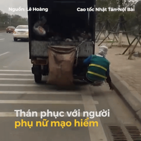 Người phụ nữ đu bám trên đuôi xe tải để nhặt rác ven đường khiến mọi người hoảng hồn