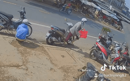 Người phụ nữ đi SH lén trộm túi thức ăn treo trên xe của người khác giữa ban ngày