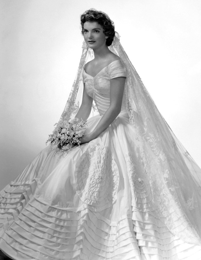 Phu nhân Jacqueline Kennedy: Trong đám cưới năm 1953, Jacqueline chọn váy cưới của Ann Lowe với những đường xếp nếp duyên dáng kết hợp hoa điểm xuyết giúp mẫu váy trở nên ấn tượng.