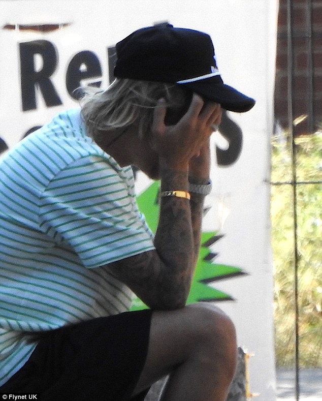 Justin ngồi ôm mặt buồn chán.