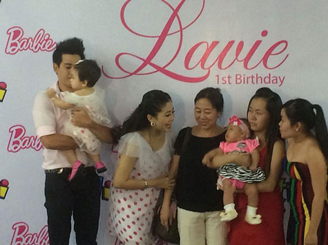 Phùng Ngọc Huy bế con gái chụp ảnh cùng dàn khách mời trong bữa tiệc sinh nhật Lavie 1 tuổi.