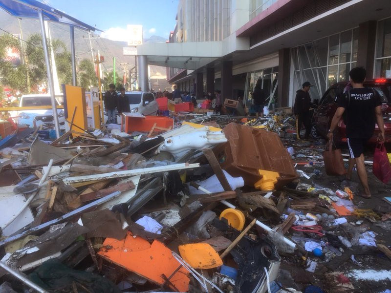 Người dân chuyển đồ dùng bên trong một trung tâm thương mại bị hư hại sau trận động đất mạnh 7,5 độ ngày 28/9.
