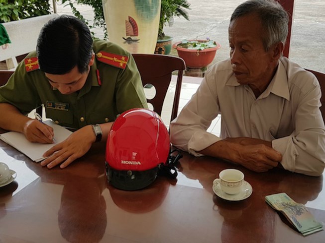 Ông Nguyễn Văn Hiếu mang cọc tiền nhặt được đi trình báo công an để trả lại người đã đánh rơi
