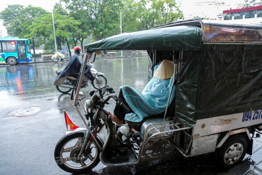 Trong buổi sáng 10/10, những cơn mưa rào kéo theo nhiệt độ giảm mạnh khiến nhiều người dân Hà Nội phải ra đường trong tình trạng co ro.   
