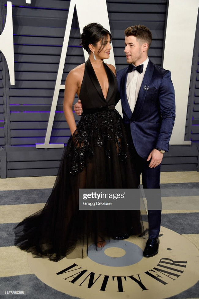 Cặp vợ chồng Nick Jonas vô cùng tình tứ khi xuất hiện tại sự kiện hậu Oscar. Mẫu đầm xẻ ngực sâu với phần chân váy sheer đính đá của Elie Saab giúp hoa hậu Priyanka Chopra khoe vẻ đẹp nóng bỏng.    