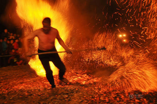 Người đàn ông cởi trần đạp lên lửa để cời than