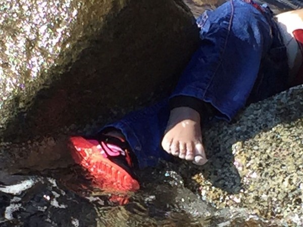 Xót xa hình ảnh thi thể bé gái mắc kẹt ở bãi đá bên bờ biển