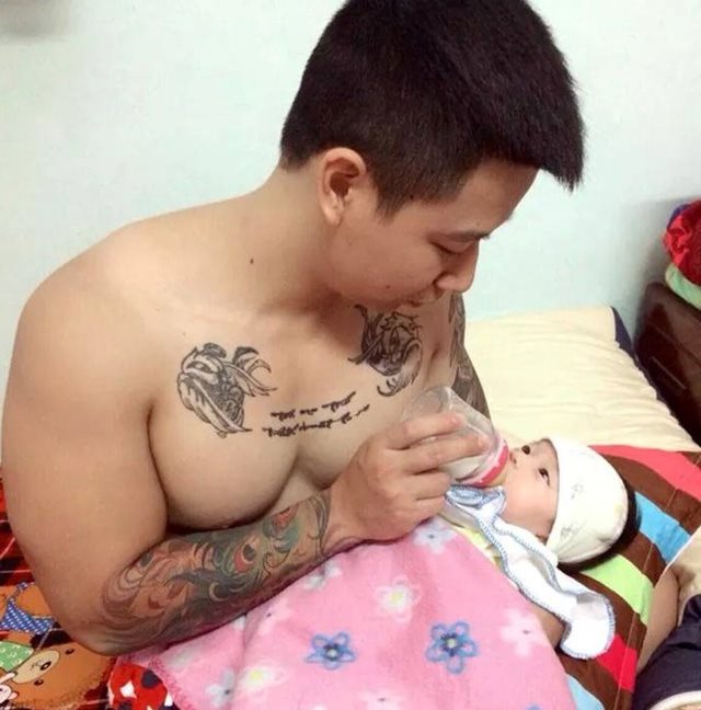 Người chồng giúp vợ cho con uống sữa.