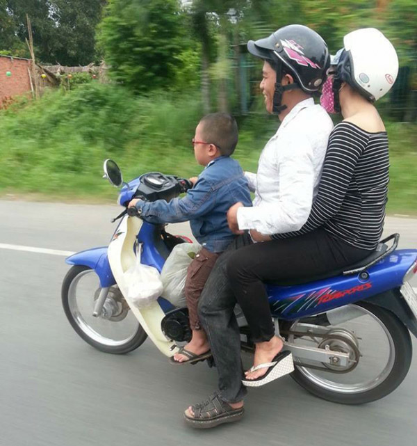 Có những gia đình còn cho con nhỏ cầm lái xe máy.