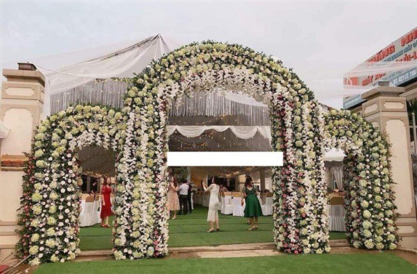 Chiếc cổng rạp cưới được trang trí bằng hoa tươi.