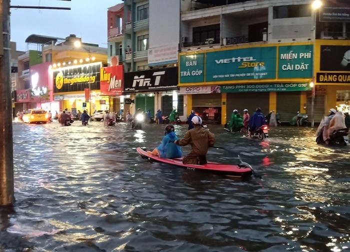 Mưa ngập khiến người dân phải dùng thuyền để di chuyển trên các tuyến đường.