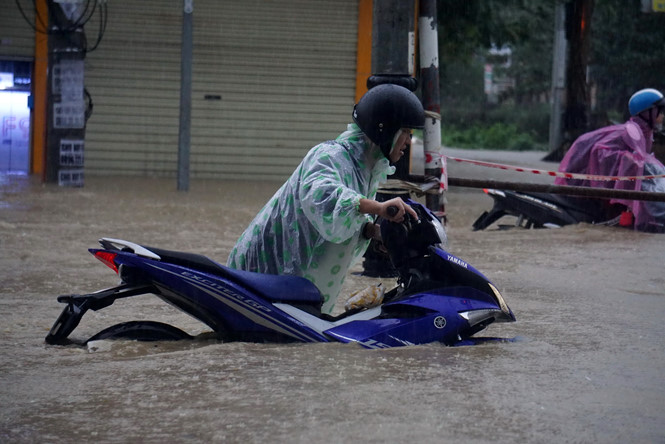 Tại Quảng Nam mưa lớn khiến một số tuyến đường lớn ngập sâu, người dân vật lộn khi di chuyển trên đường.