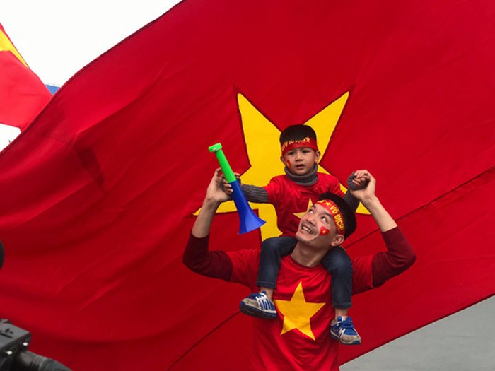 Hai cha con cháy hết mình cùng ủng hộ các cầu thủ chuẩn bị xuống sân bay.
