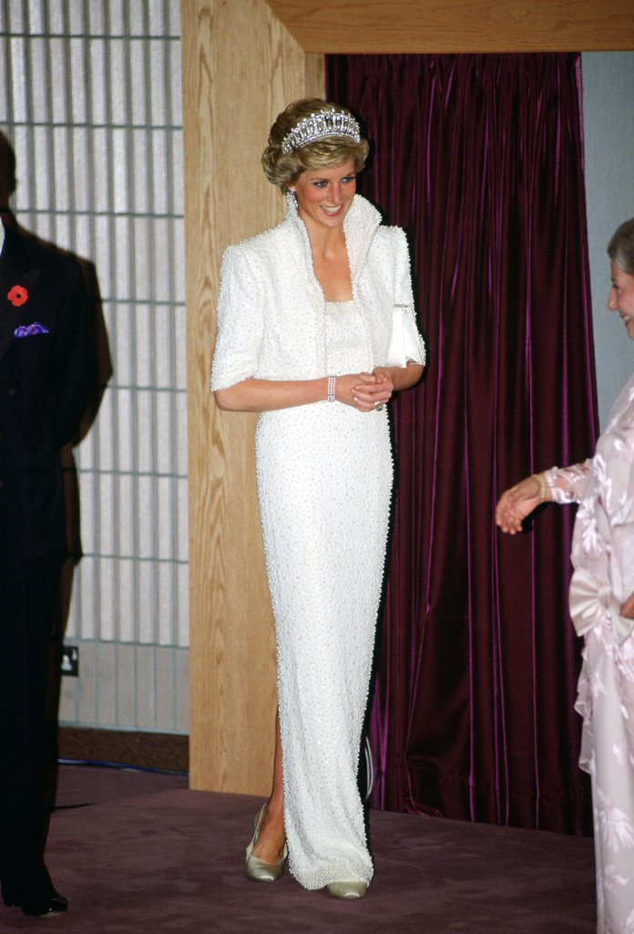 Mẫu váy trắng đính kết ngọc trai cùng chiếc vương miện danh giá giúp Công nương Diana trở nên thanh lịch và nổi bật hơn trong chuyến thăm Hong Kong năm 1989.