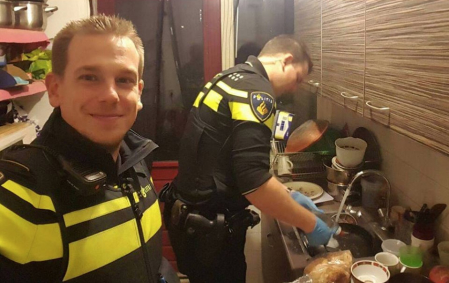 Hai cảnh sát trẻ rửa bát và chuẩn bị bữa trưa cho 5 đứa trẻ khi mẹ các em phải vào viện cấp cứu. Ảnh: Twitter.