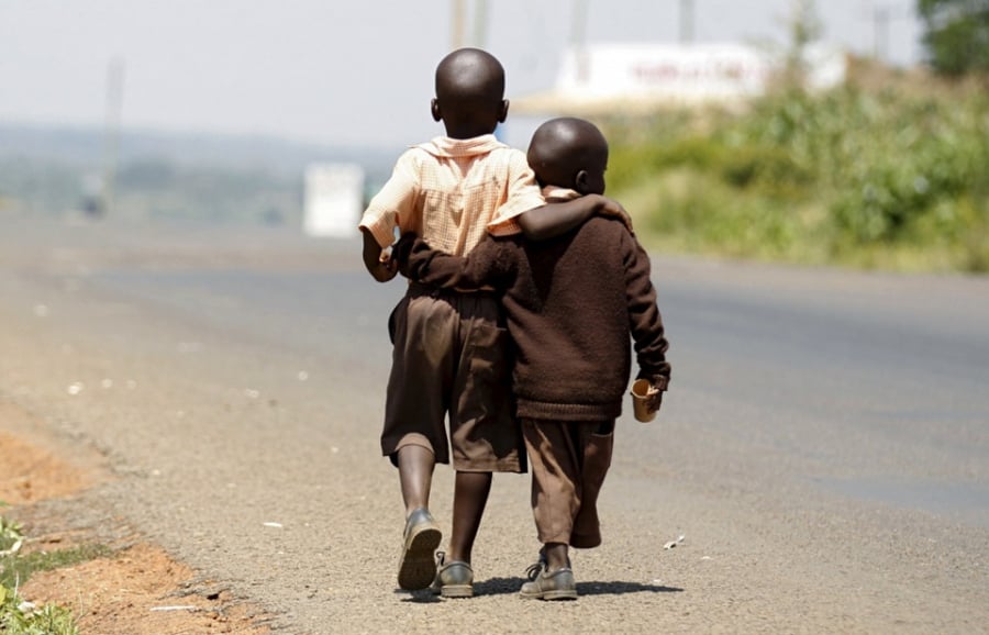 Đôi bạn nhỏ khoác vai nhau trên đường đi học về ở thành phố Nairobi, Kenya. Ảnh: Thomas Mukoya/Reuters.